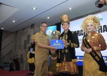 Asisten Administrasi Umum Sekda Aceh Iskandar, didampingi Kepala Dinas Arsip dan Perpustakaan Aceh Edi Yandra, menyerahkan hadiah sekaligus menobatkan Raja dan Ratu Baca Aceh terpilih, pada acara penobatan raja dan ratu baca Aceh, di Aula Perpustakaan Wilayah, Senin (5/8/2024).