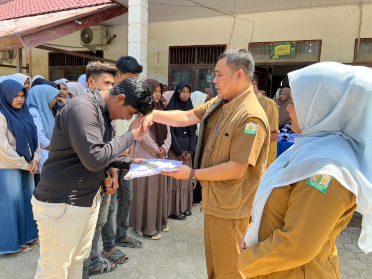 Kacabdin Aceh Utara Muhammad Johan Serahkan Seragam untuk Siswa Korban Banjir, Pastikan PBM Tetap Berjalan